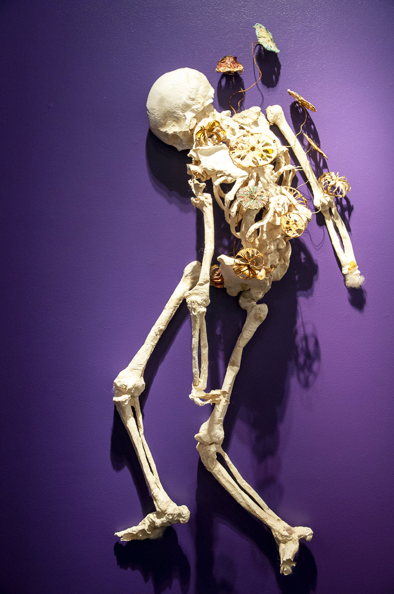 "Lozano" is an almost life-size paper cast of a full-body human skeleton that hangs on the wall with fungi sprouting from its torso. The patina of the fungi is a nice contrast to the starknes of the skeleton.