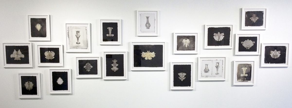 "Specimens" presents ghostly Rorschach-like abstracted shapes in a series of white frames. Some of the images are created through blowout papermaking techniques, pulp painted, or use a photographic contact print called a Kallotype. Though three different techniques were used, the black and white palette along with the formal framing create a cohesive installation.