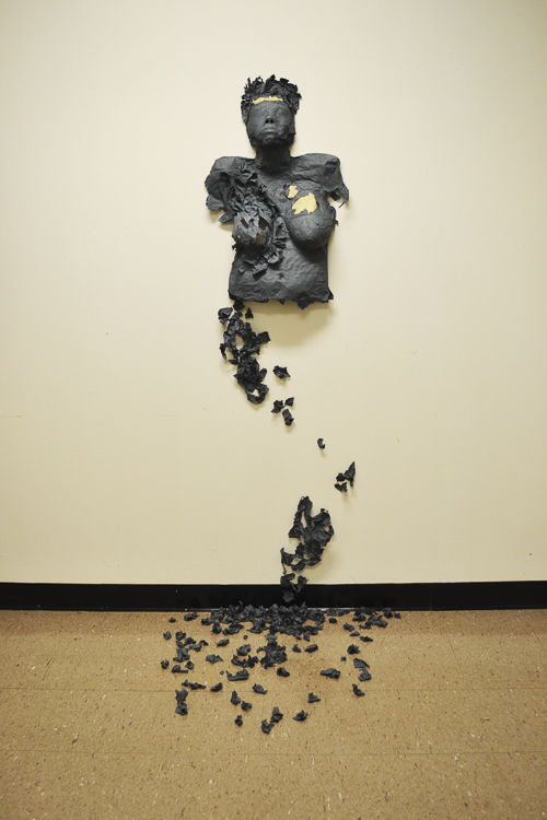Using pulp created from the clothes of transgender individuals, "Dysphoria" is an installation of a cast paper head and armless torso with breast that appears to be crumbling or dissipating down the wall into little paper pieces scattered about on the floor. 