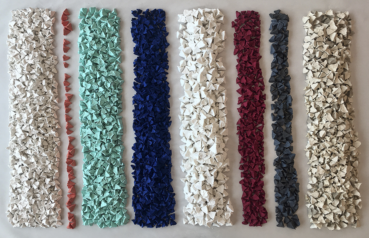 "Zheng" consists of triangular-shaped paper pebbles arranged in rows of varying widths based on color.  