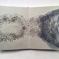 This untitled artist book shows a swarm of black dots of various sizes interacting with blue-grey pulp paintings that look both like clouds or tusche washes. The slightly grey paper provides a warm more enticing composition.