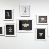 "Specimens" presents ghostly Rorschach-like abstracted shapes in a series of white frames. Some of the images are created through blowout papermaking techniques, pulp painted, or use a photographic contact print called a Kallotype. Though three different techniques were used, the black and white palette along with the formal framing create a cohesive installation.