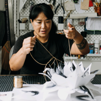 Photographer & Book Artist Colette Fu pulling the strings of a pop-up in her studio.