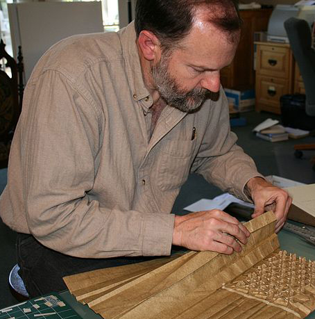 Mathematician and Engineer, Roberrt Lang, engrossed in folding a sheet of origami