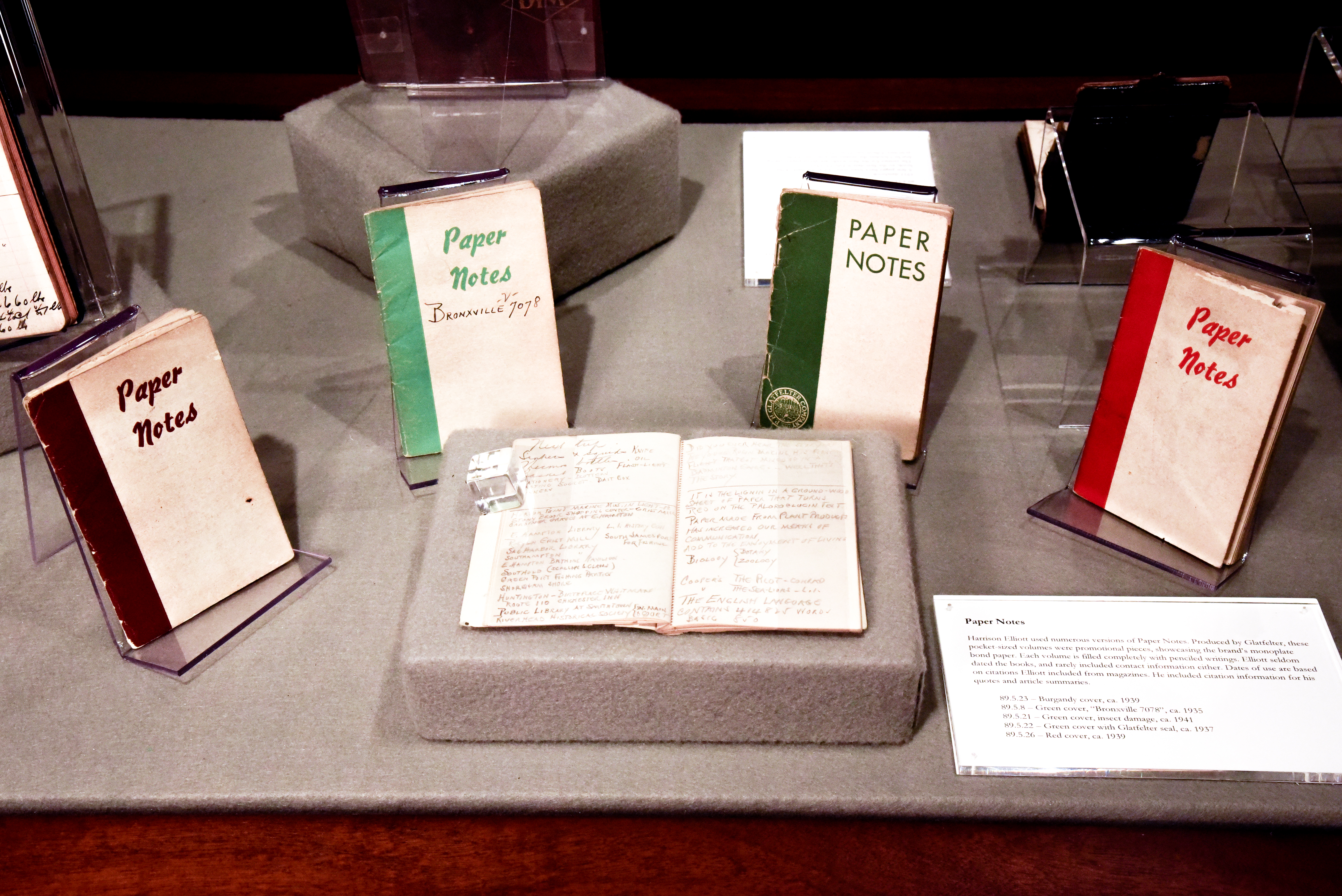 5 pocket sized volumes titled "Paper Notes" , 4 are closed showing their covers, each with a colored spine and lettering on a white background, the 5th notebook is open to a page of handwritten notes in pencil. 