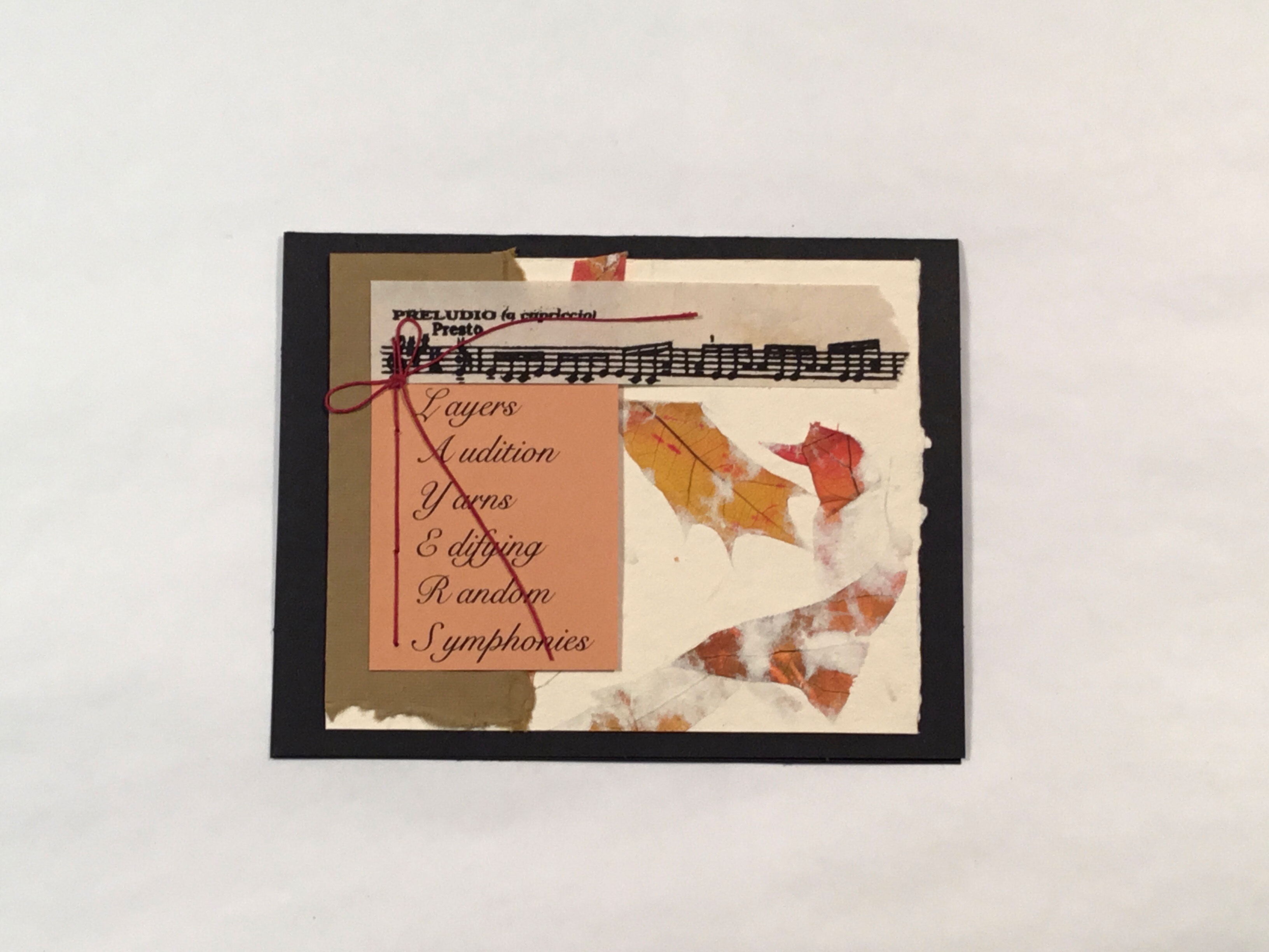 A collaged image of a bar of sheet music, leaves on crème paper, brown torn paper on the lefthand side, and a pale orange square of paper with an acrostic poem that says “Layers Audition Yarns Edifying Random Symphonies”, spelling out “Layers”, and a red thread tied in a bow on top.
