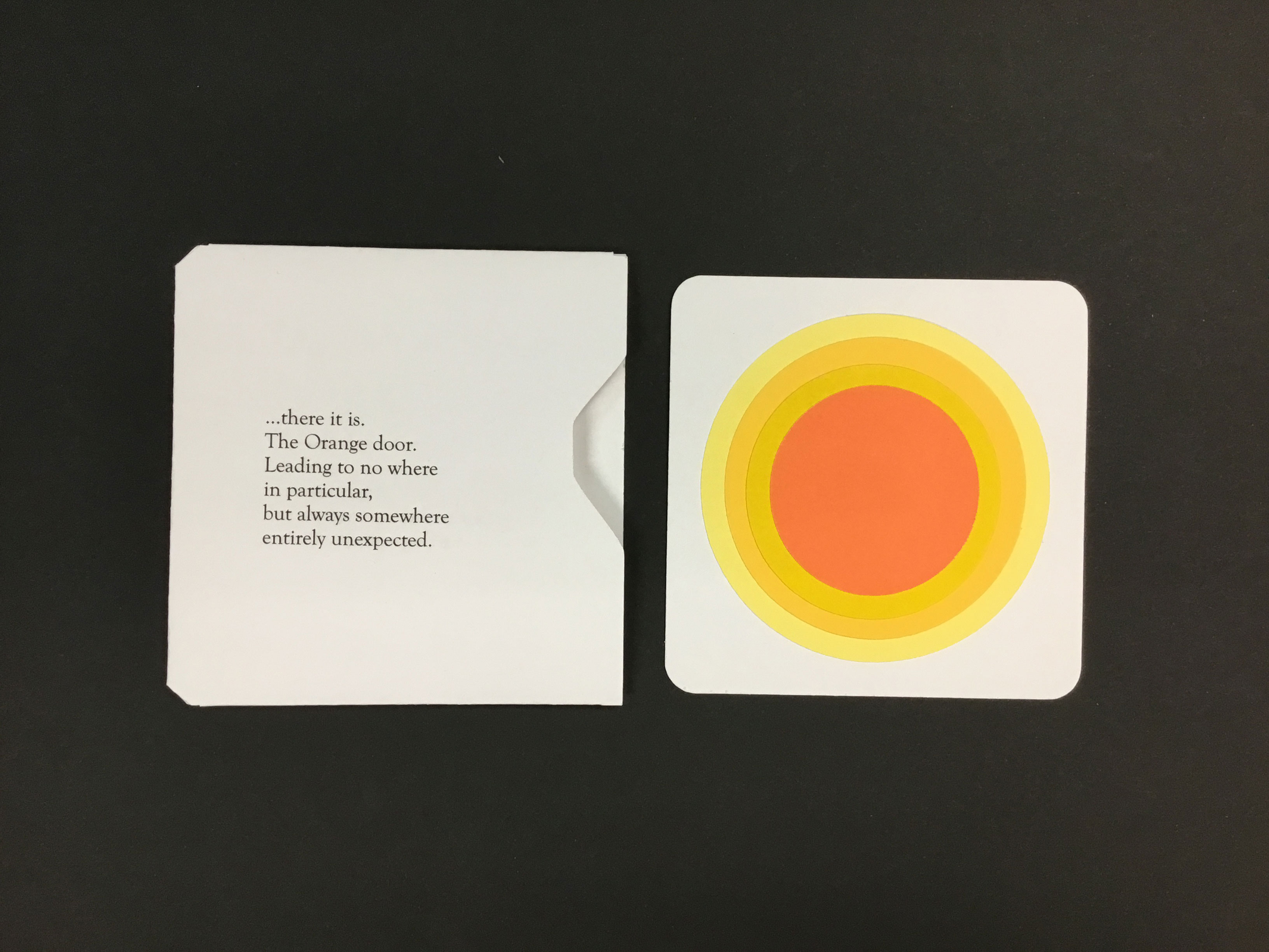This piece is comprised of an square, white envelope with a poem on it and a square sheet of paper with concentric yellow and orange circles in the center.