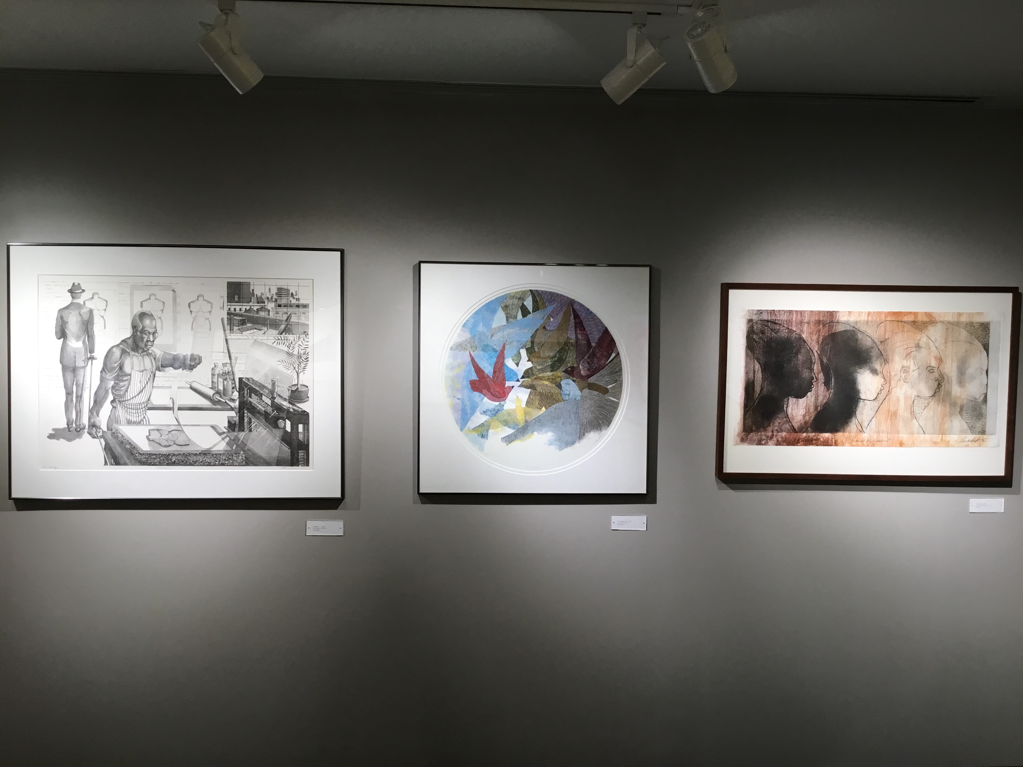 An image of a wall of the second gallery that features three large, framed prints.