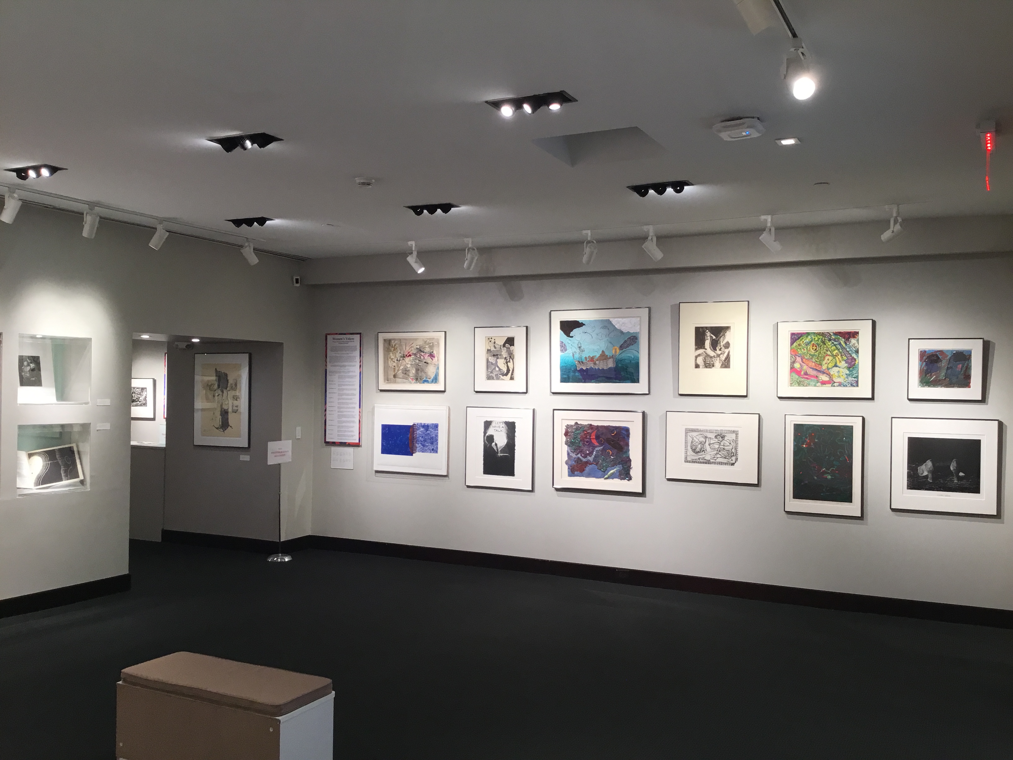 An image of the front corner of the main gallery that features multiple framed pieces, as well as placards that read “A Community of Artists” and “Georgia Artists”.
