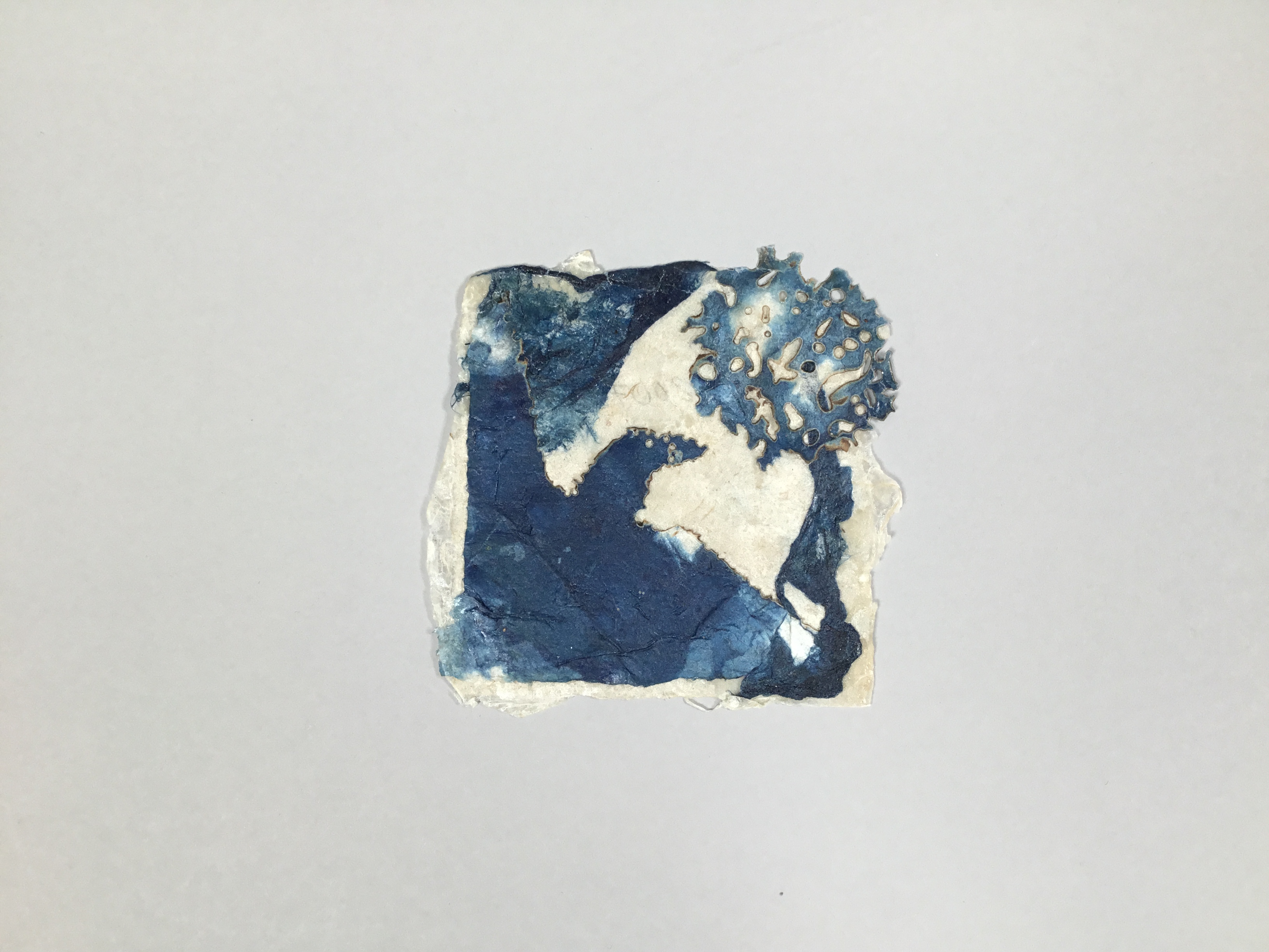 This piece is a square sheet of handmade paper with a blue and off-white abstract pattern on the front. 