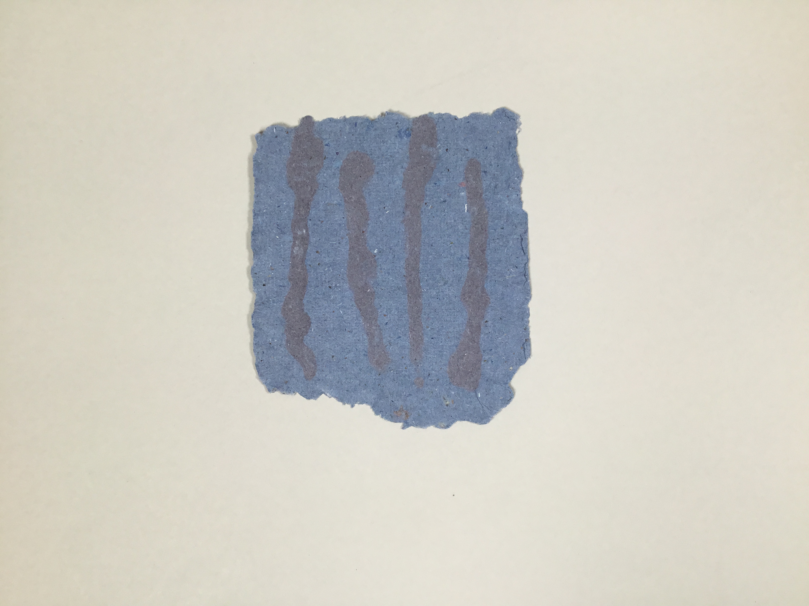 This piece is a roughly square sheet of navy handmade paper with four darker blue vertical stripes painted on top.