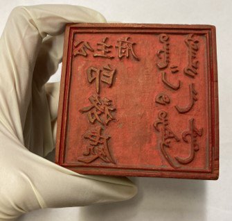 Holding a Chinese woodblock from museums collection