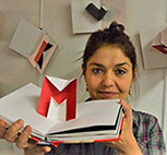 A photo of graphic designer and pop up artist Marion Bataille holding ABC3D open to the M page