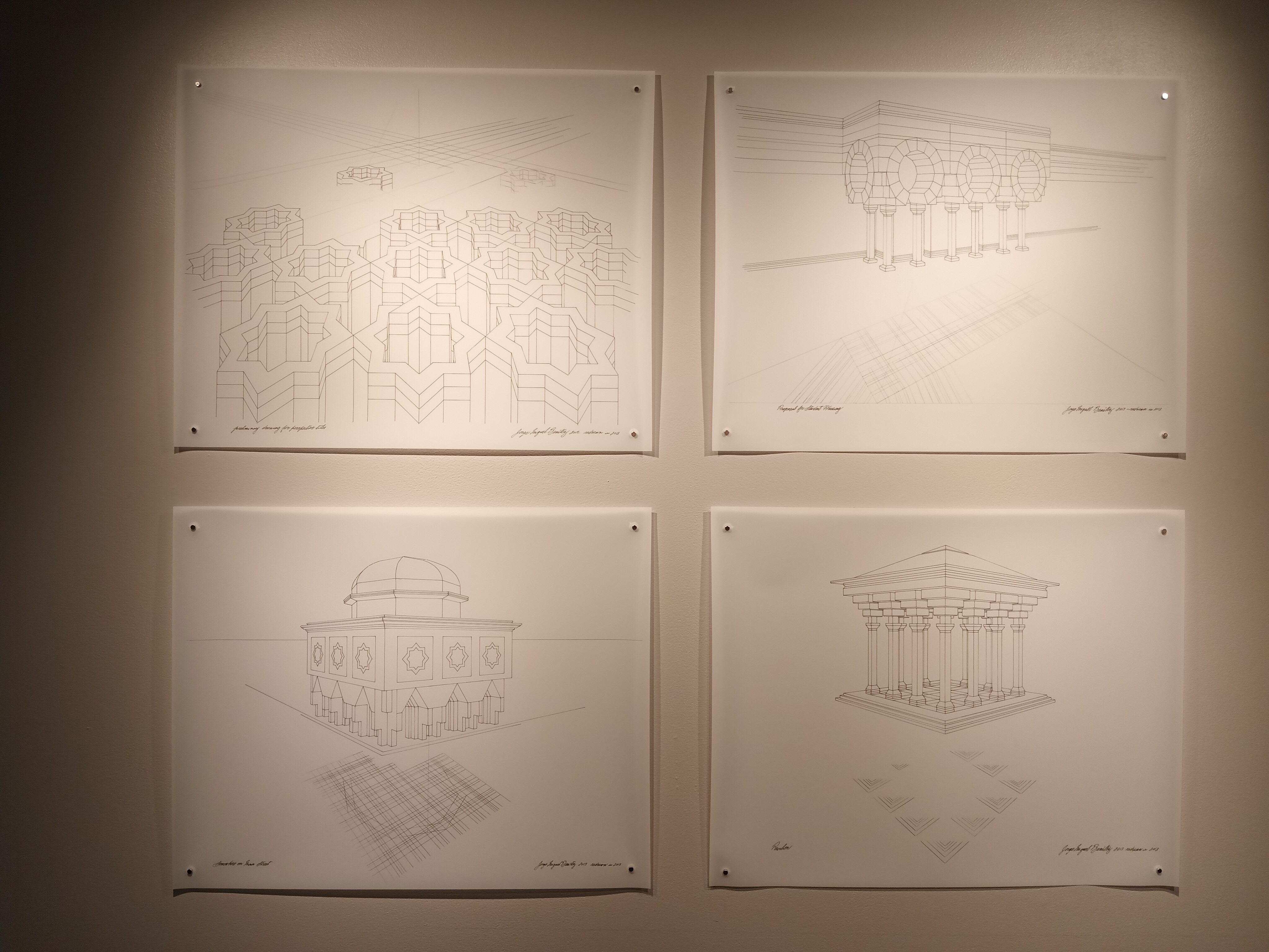 Four perspective drawings in graphite on white paper displayed on a gray wall. Top left is a drawing of an array of eight-point star tiles and voids. Top right is a drawing of a row of square columns supporting four circular arches. Bottom left is a drawing of a square building with a row of columns at the base, a row of the stars in a band along the middle, topped with an octagonal dome. Bottom right is a drawing of a set of square columns arranged in a square, supporting a tiered pyramid roof.