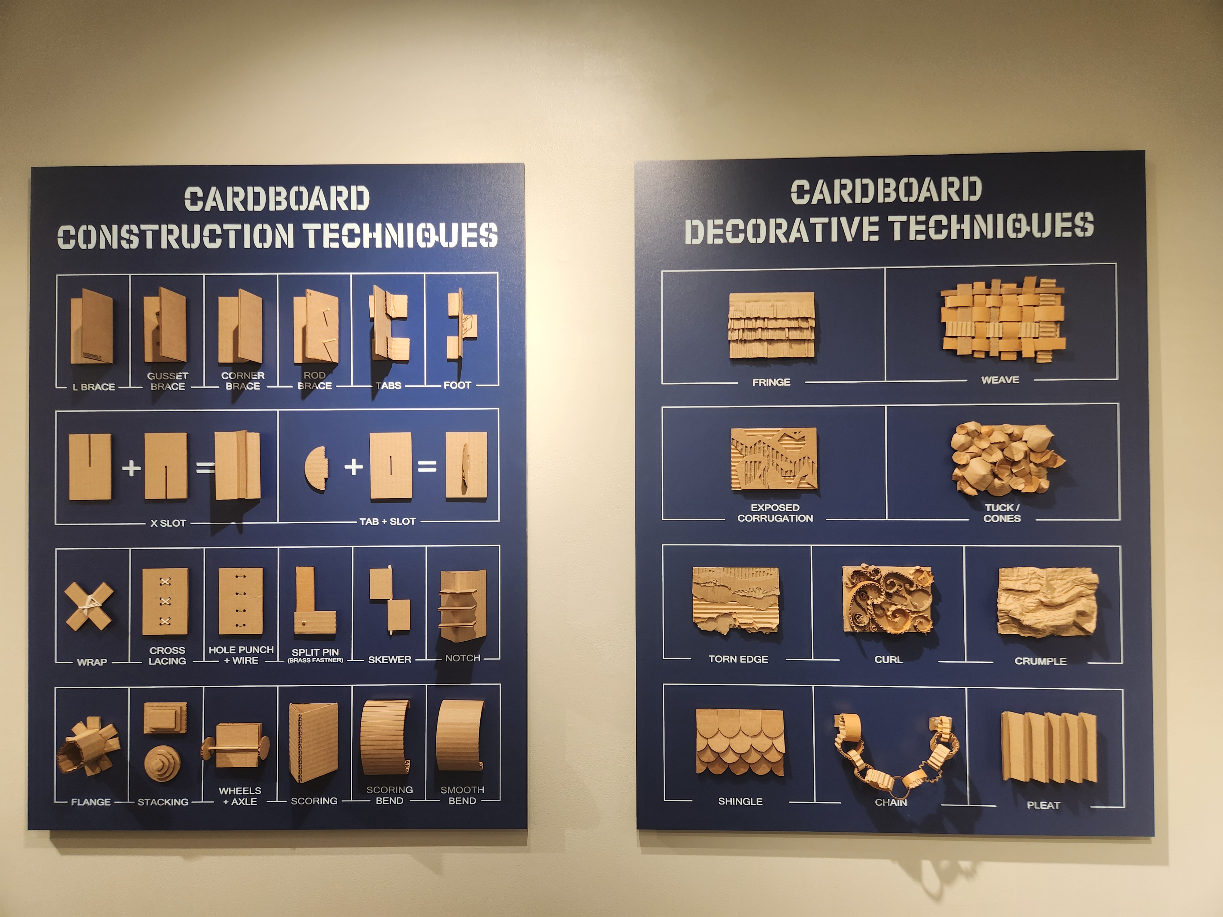 Two purple display panels with white lettering. The left panel has a number of Cardboard Construction Techniques, and the right panel displays several Cardboard Decorative Techniques.