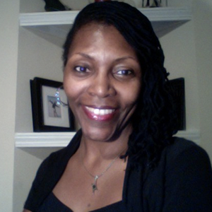 Bio headshot of Amanda Ray, an African-American woman wearing long braids smiling directly at the camera.