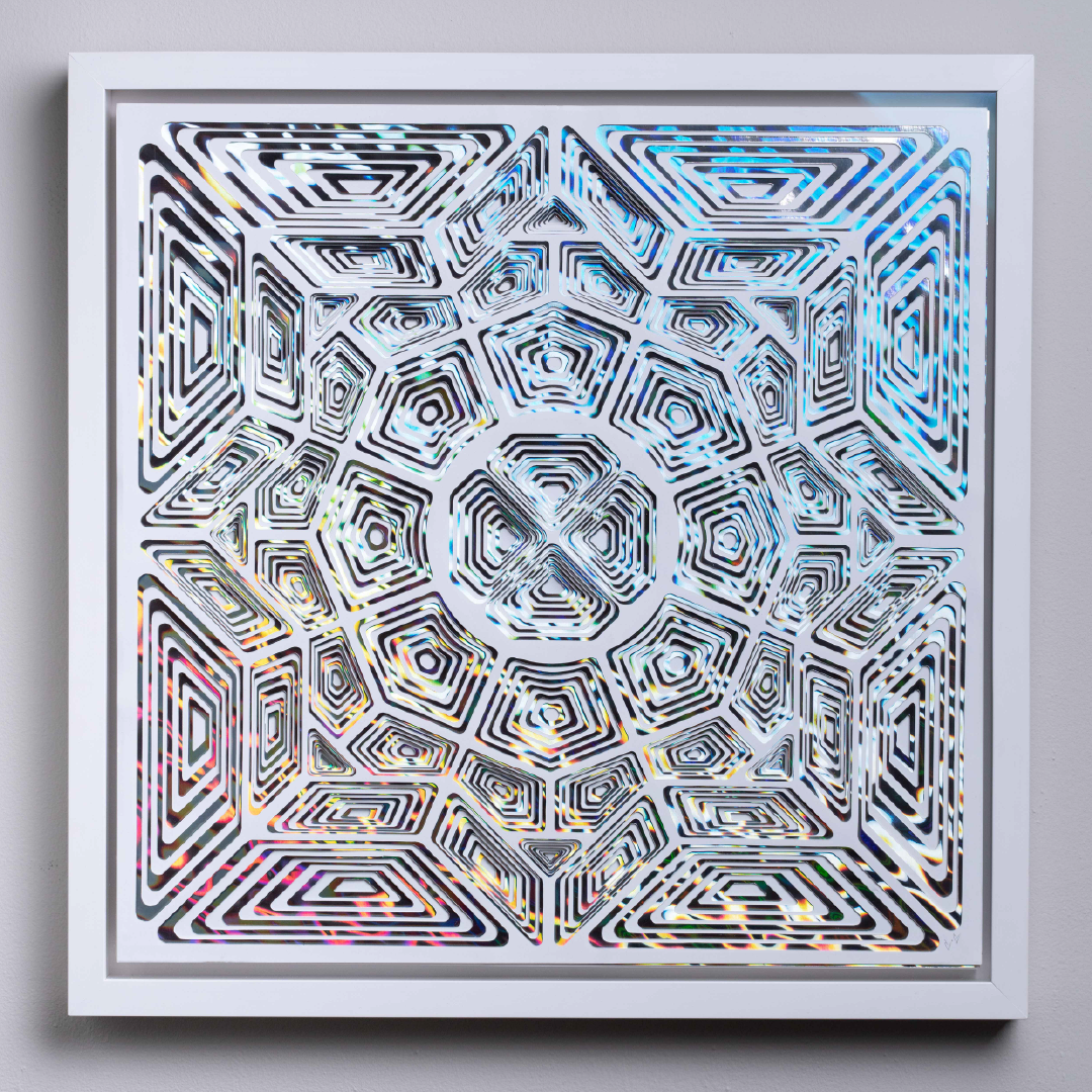 A geometric paper-cut sculpture with alternating layers of white and holographic papers.