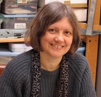 Photo of book artist Carol Barton smiling at the camera.