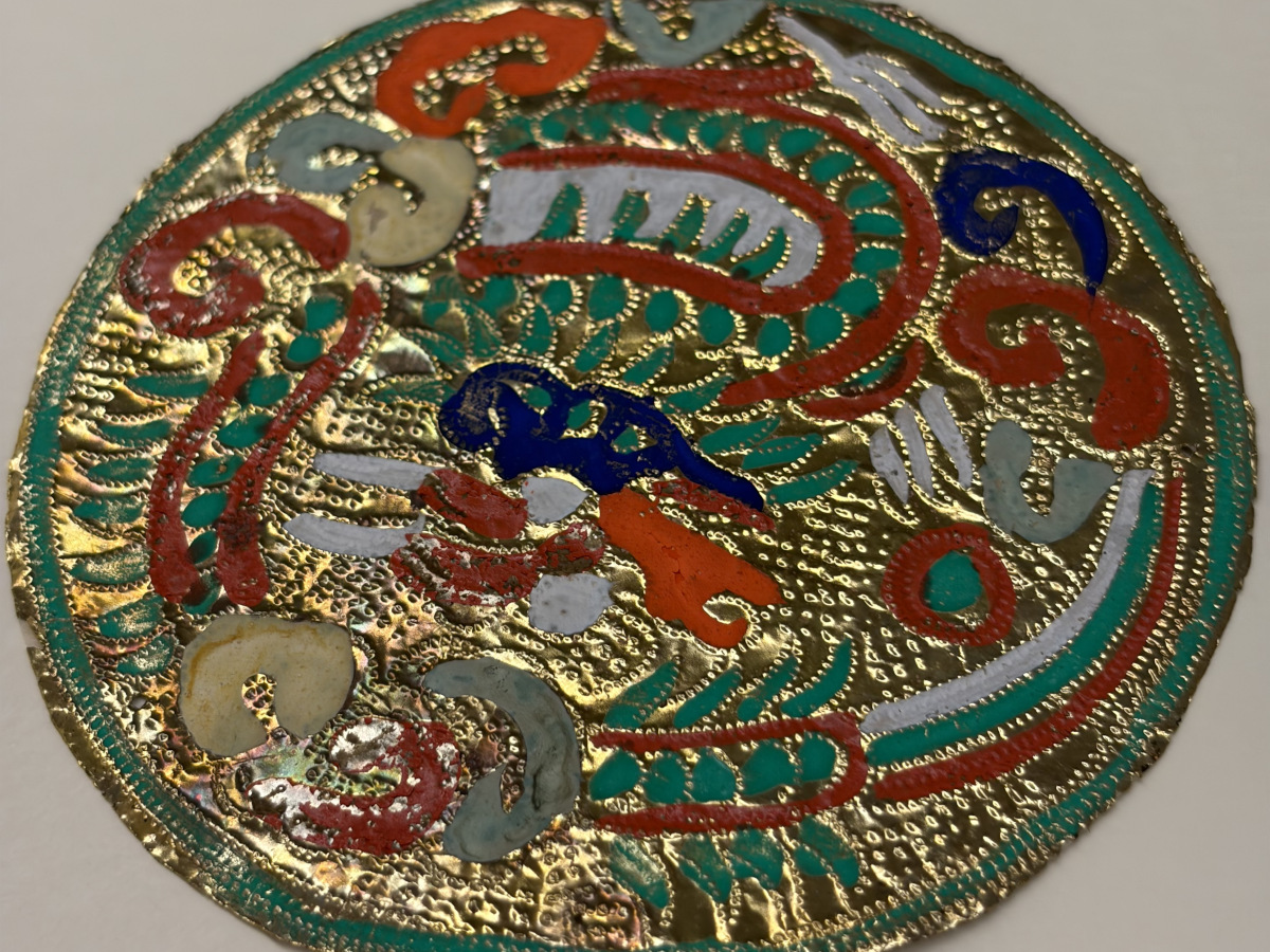 A vibrantly colored embossed foil in the shape of a circle.