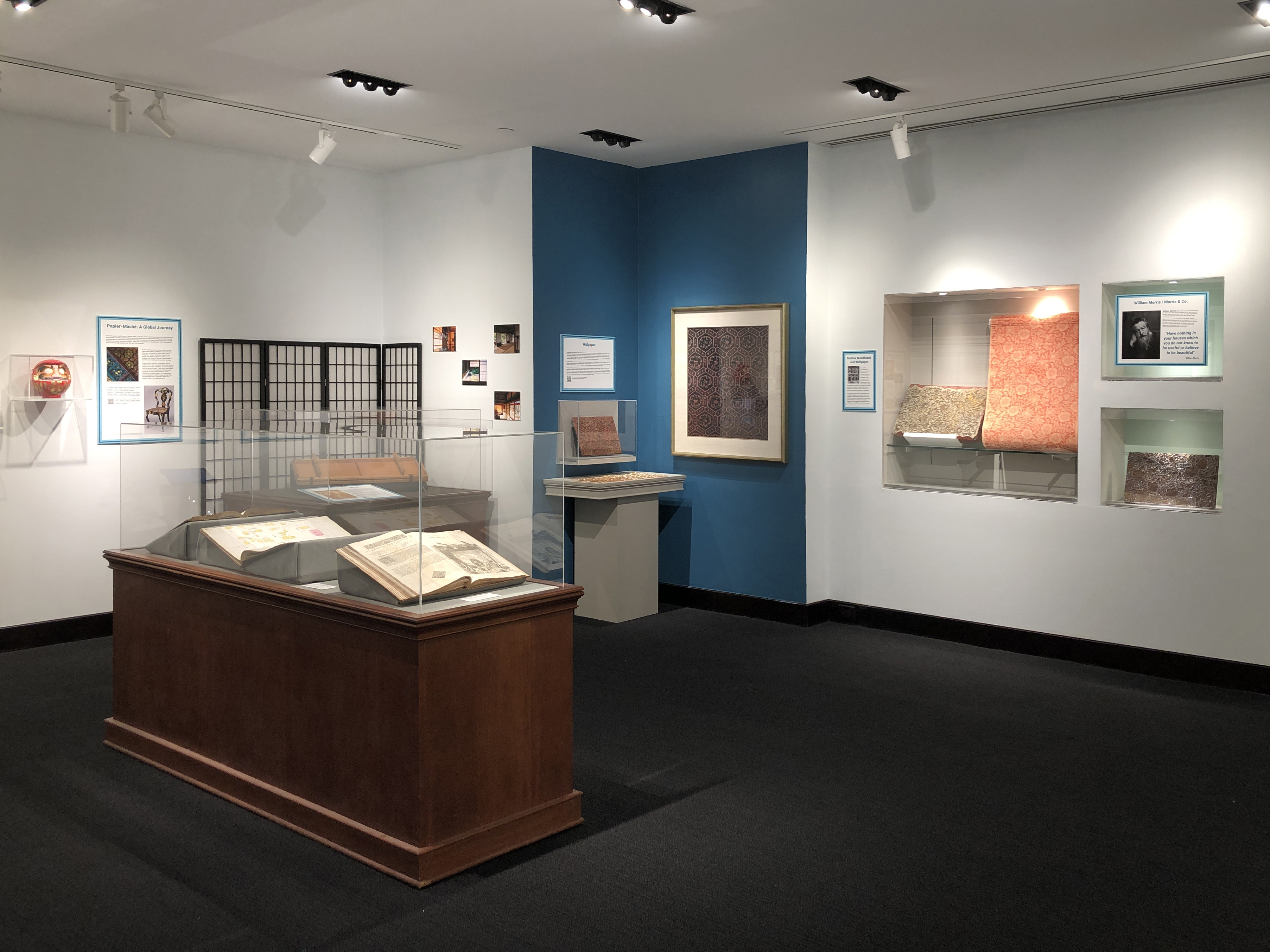 Gallery view of Transformed Environments; in the foreground is a large case displaying open books. 