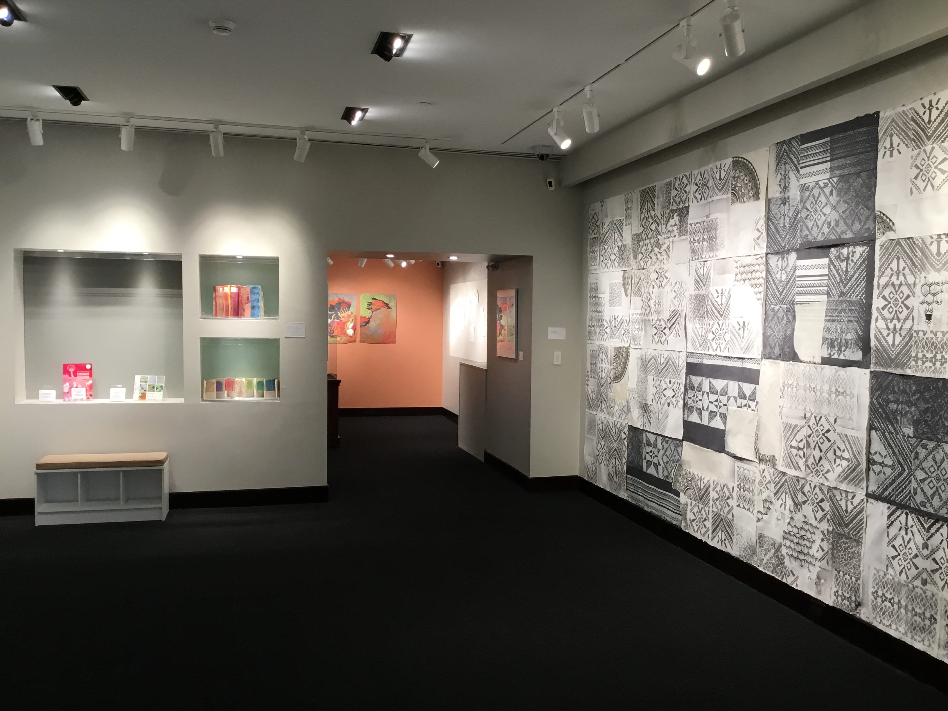 The right wall of the first room, leading into the back room. The wall is covered in sheets of black and white patterned paper cut and pasted together.
