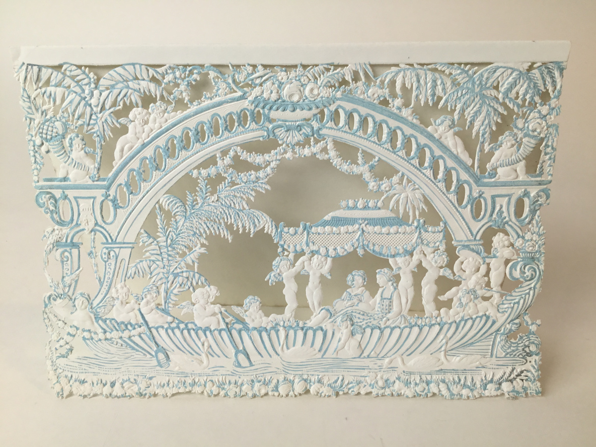 A full shot of a blue and white greeting card that shows all of the details and the shadows created by the die cut method.