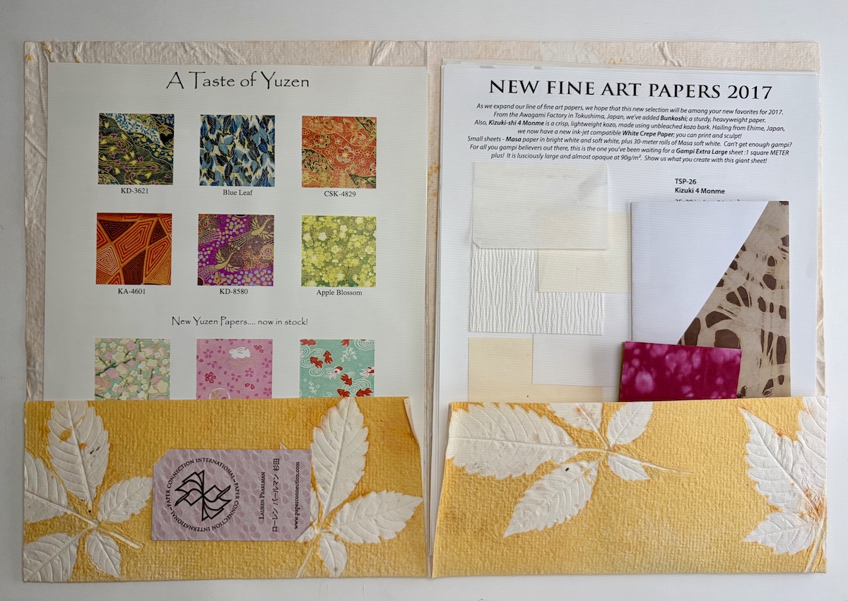 Inside of the folder that contains paper samples with different textures and colors.