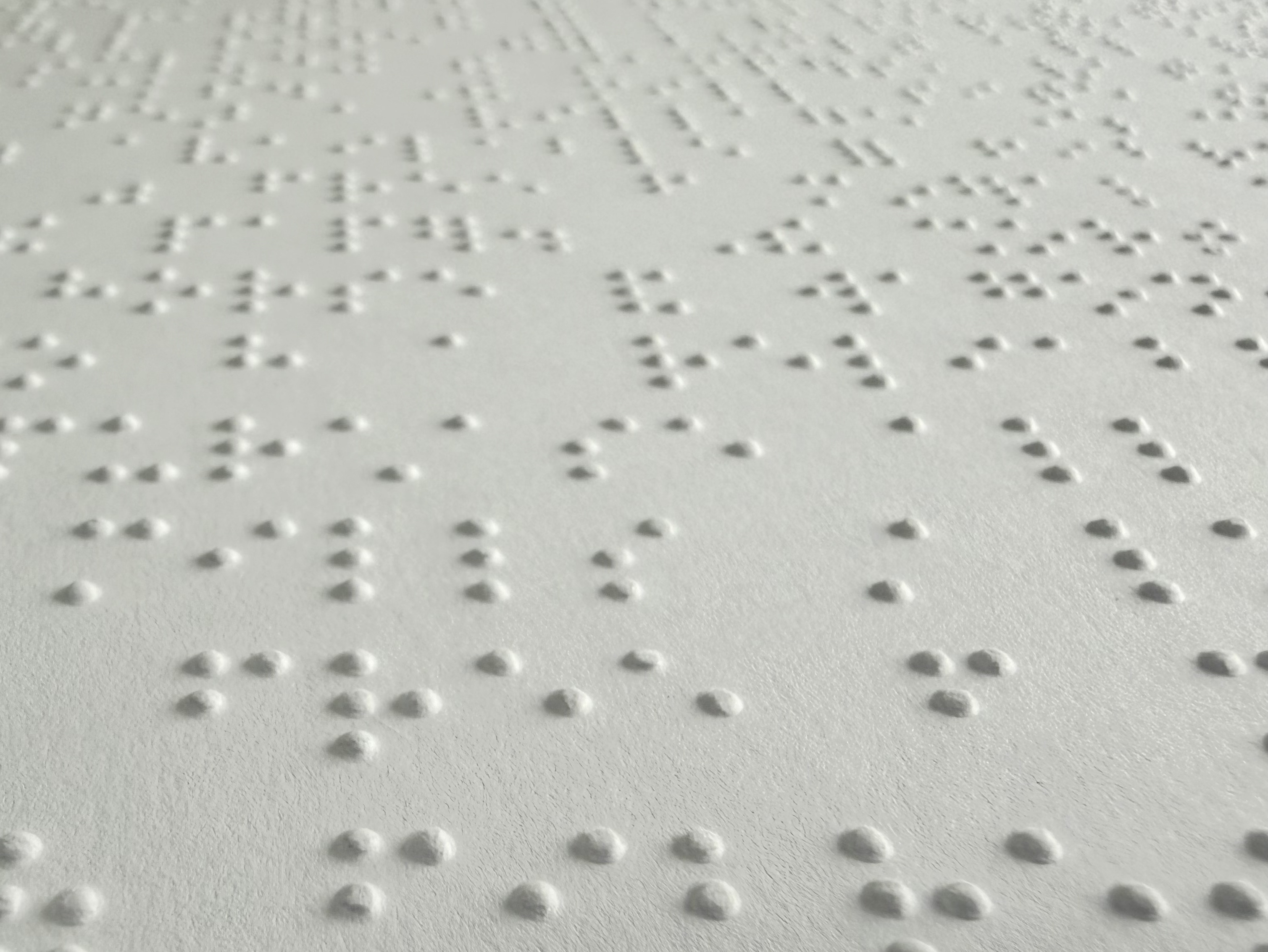 A zoomed-in shot of braille on white paper.
