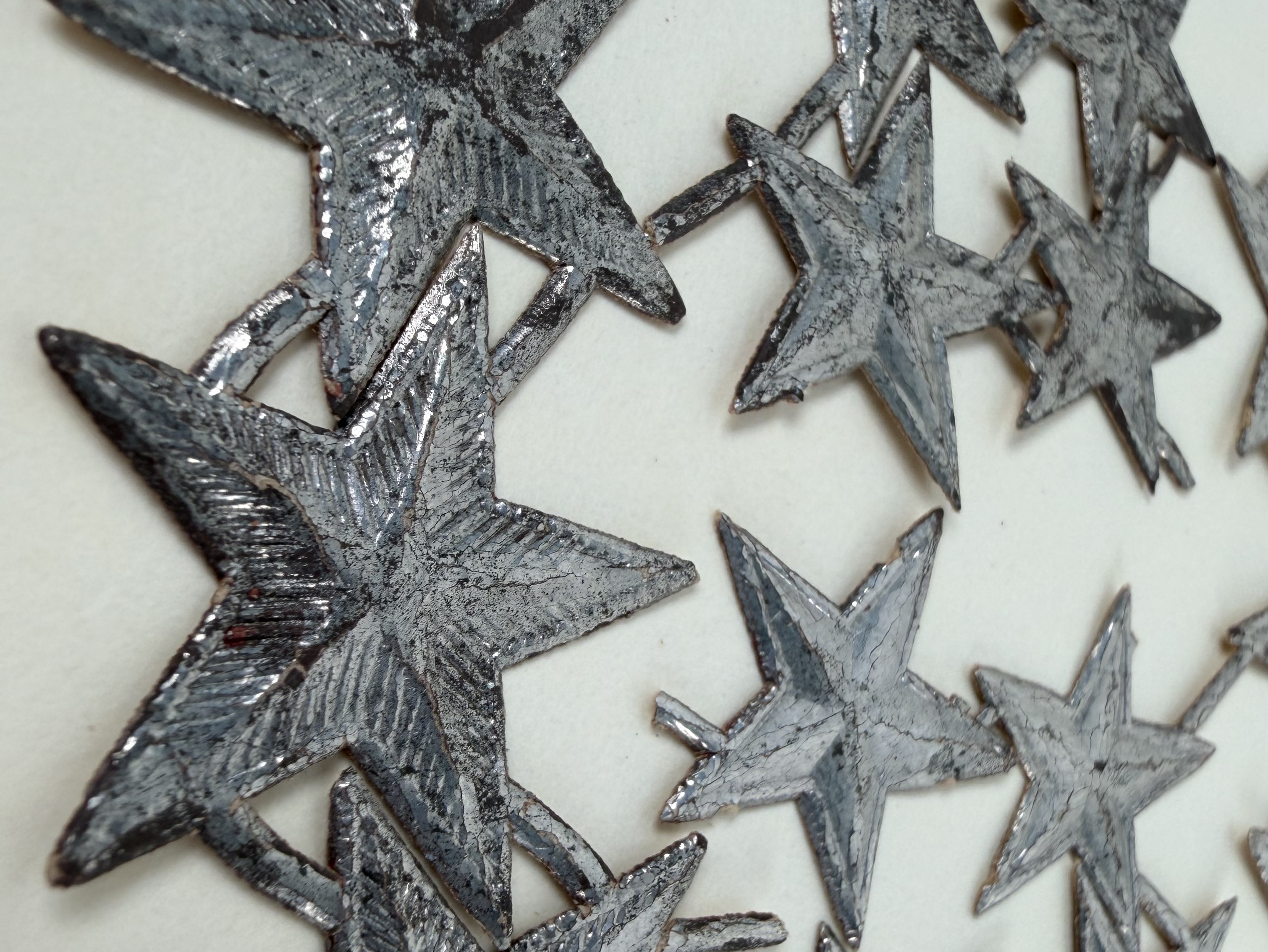 Raised silver star shapes on white background.