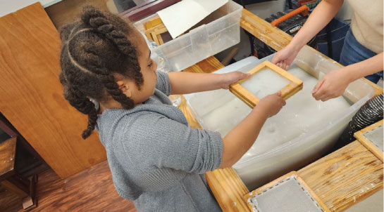 Young girl making paper
