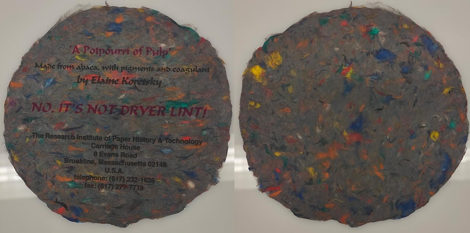 Circular, grey paper with colorful inclusions, front and back.