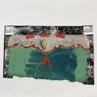 Off-white brocade mantlepiece with relief of a face in the center on a black and white plant-like background with blue and green paper in the midground and orange brushstrokes outlining the mantel.