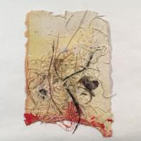 A light yellow and beige piece of paper with deckled edges and scraps of hair, thread, and plastic strings scattered throughout the page. The bottom edge is dyed red.