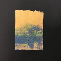 A rectangular sheet of yellow-beige handmade paper with blue streaks occupying the lower half. The top of the paper has a raw edge.