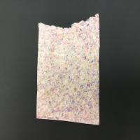 A rectangular sheet of brown, green, pink, and navy pigments with a large cut-out raw edge on the top of the piece. The paper, made from abaca and kozo, was created using a pulp-spraying technique. The back of the paper is light pink flecked with shades of purple and yellow.
