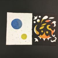 A book whose front cover has two circular holes cut out of it, revealing blue and yellow paper underneath. The cover is white with pulp flecks, and each page is either entirely black with abstract, geometric cutouts or is similar to the cover with circular cutouts and orange, purple, or yellow paper underneath.