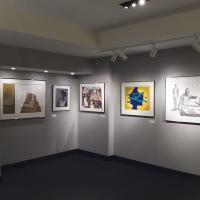 An image of the front corner of the second gallery, featuring five framed prints. 