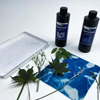 blue and white cyanotype fabric, white tray, cyanotype chemicals and plants