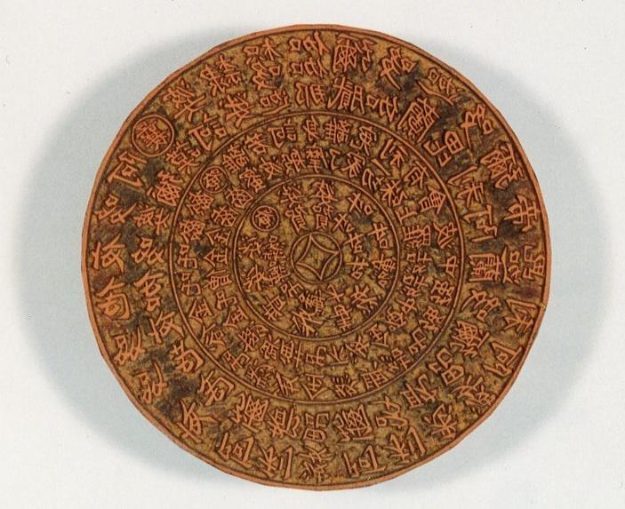 Round woodblock with Chinese characters in concentric circles.
