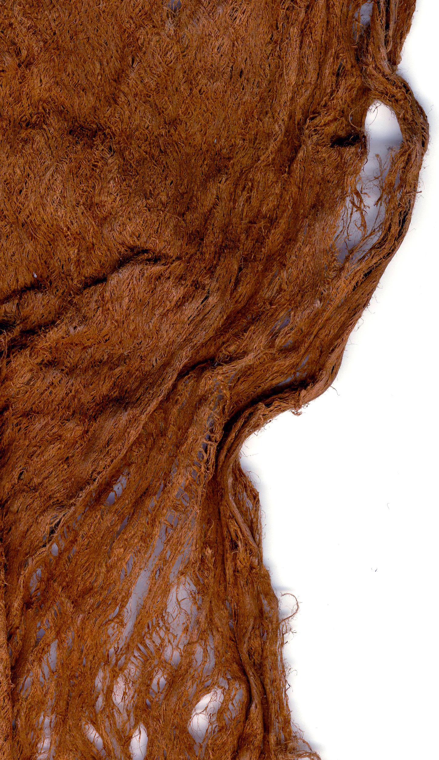 Close up image of a reddish brown tapa cloth sample focused on the material's texture 