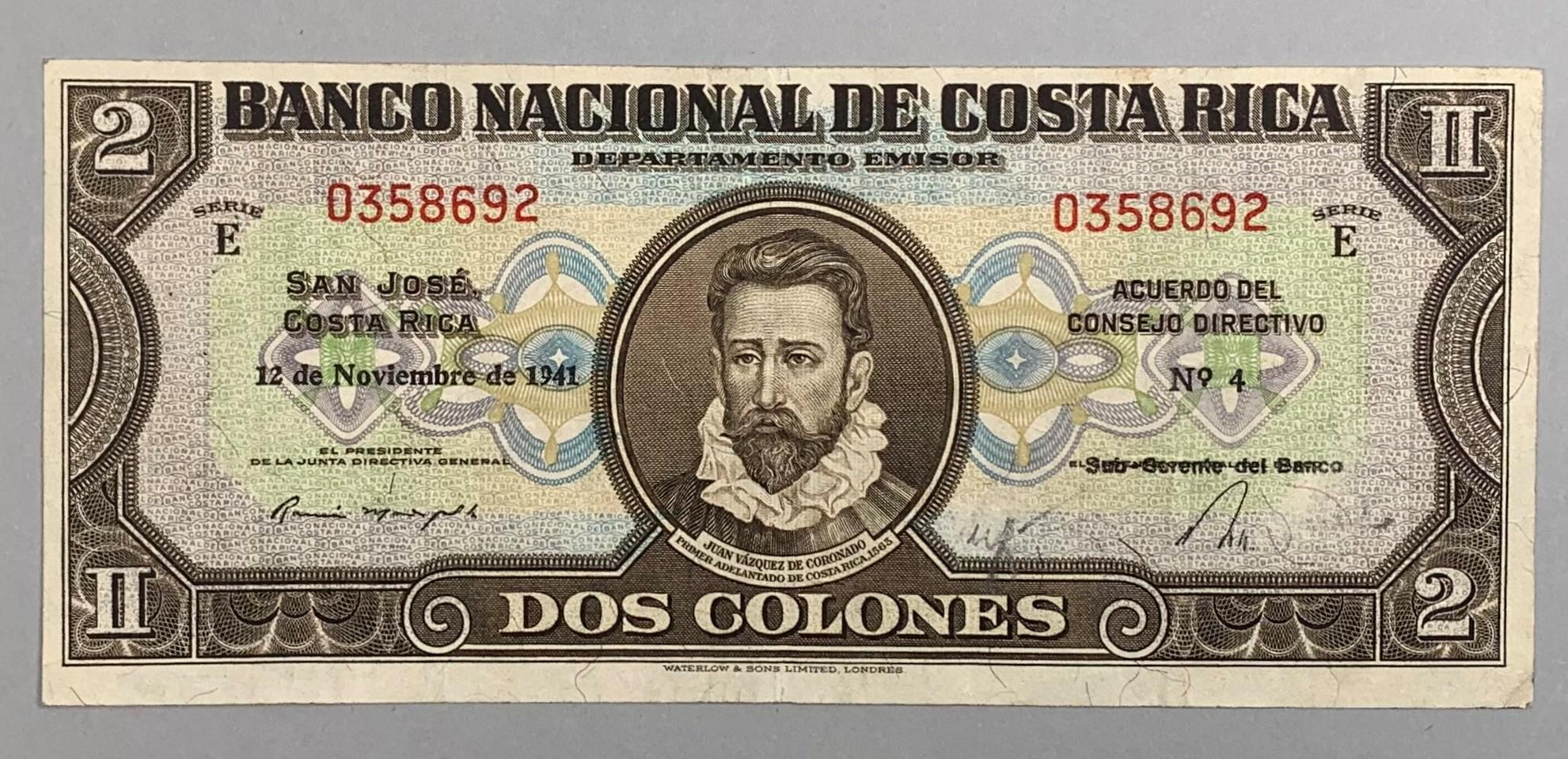The front of the bill is mainly brown on a multi-colored background made up of a pattern that reads “BANCO NACIONAL DE COSTA RICA” which translates to “National Bank of Costa Rica.” The bill is titled “Banco Nacional de Costa Rica Departamento Emisor” and “Dos Colones” between which there is a three-quarter bust portrait of Juan Vázquez de Coronado that is captioned with his name and the assignation of “Primer Adelantado de Costa Rica, 1565.” 