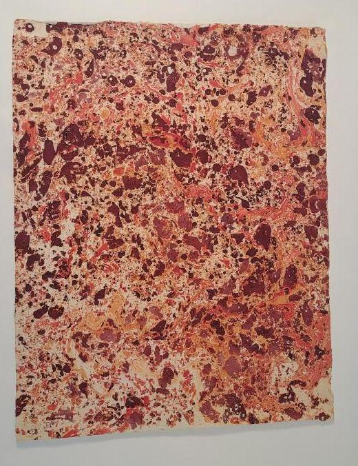 A sheet of red and orange marbled paper