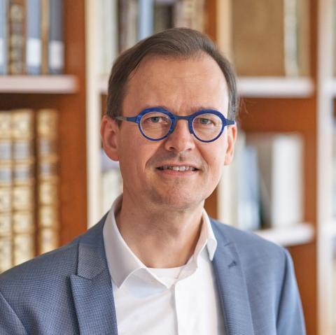 Headshot photo of Dr. Joran Proot. A man with short brown hair and blue glasses.