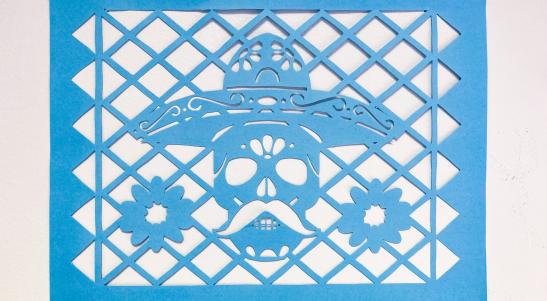 paper cut with skull wearing a hat and flowers